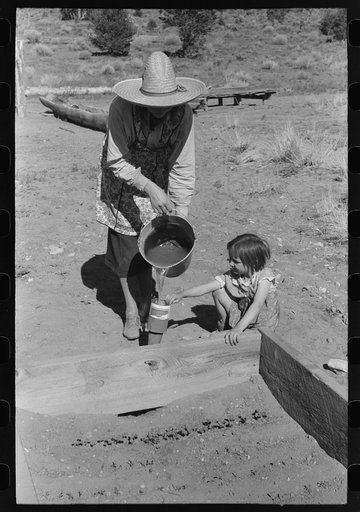 Mrs. Caudill and daughter watering frame garden, Pie Town, New Mexico