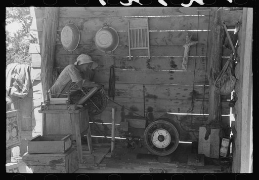 Mrs. Hutton opens electric washing machine. Her son put in all the electric equipment. Pie Town, New Mexico