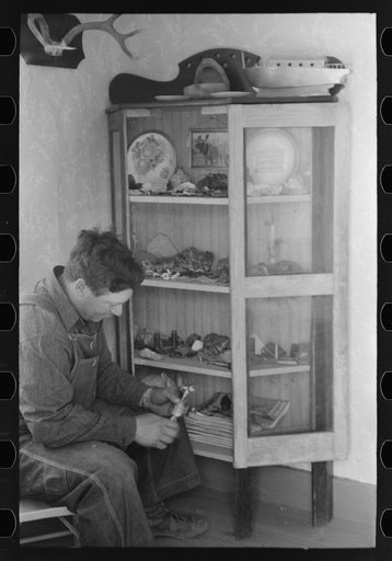 Untitled photo, possibly related to: George Hutton, Jr. examines fetish used in Indian cermonies. He has a collection of rocks, curios, and Indian relics which is highly prized by the entire family. Pie Town, New Mexico