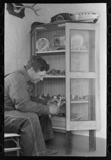 Untitled photo, possibly related to: George Hutton, Jr. examines fetish used in Indian cermonies. He has a collection of rocks, curios, and Indian relics which is highly prized by the entire family. Pie Town, New Mexico