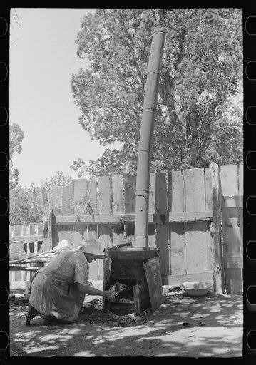 Mrs. Hutton builds fire in outdoors burner which heats the water for laundering. Pie Town, New Mexico