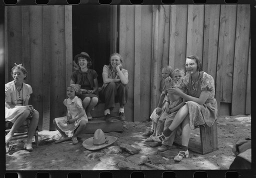 Farm women and children laughing at some antics of the menfolks. This was taken during an all day Sunday visiting to celebrate a birthday. Pie Town, New Mexico