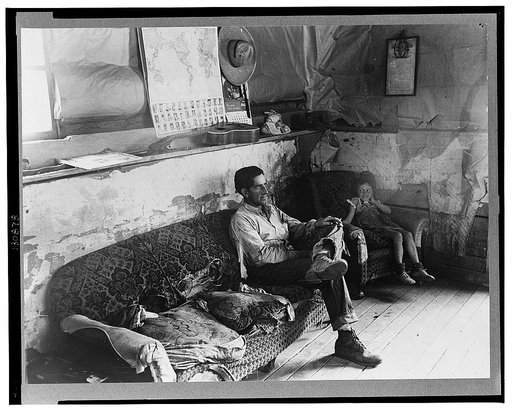 Faro Caudill and his daughter in their dugout home. There hasn't been any cash to buy furniture. Farm expenditures take all extra cash. Pie Town, New Mexico