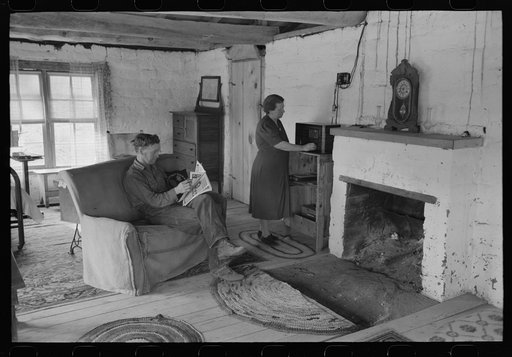 Homesteader and his wife in the living room of their new adobe house. This couple came out seven years ago from Oklahoma and lived in a log cabin until building this winter the adobe house. Pie Town, New Mexico
