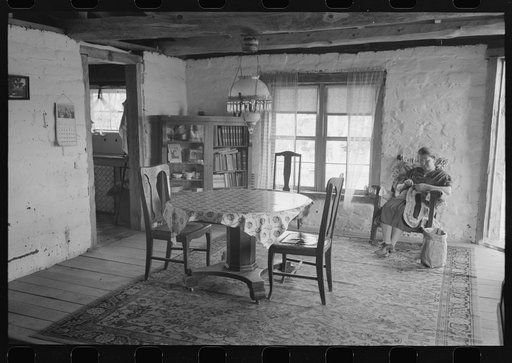 Wife of homesteader working in dining room of her new adobe house. The lamp-chandelier above dining table was brought by her grandmother to Iowa when she homesteaded there. Pie Town, New Mexico