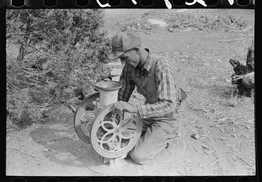 Untitled photo, possibly related to: Jack Whinery grinding pinto beans for chicken feed, Pie Town, New Mexico