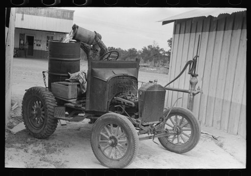 Untitled photo, possibly related to: Homesteader pumping water which he will haul home from town. Wells require cash to drill and some farmers have not yet been able to drill their own wells. Pie Town, New Mexico