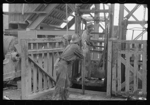 Miners loading drilling equipment onto hoist to take. Mogollon, New Mexico