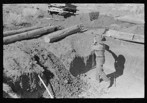 Untitled photo, possibly related to: Faro Caudill shoveling out dirt while building steps of his dugout, Pie Town, New Mexico