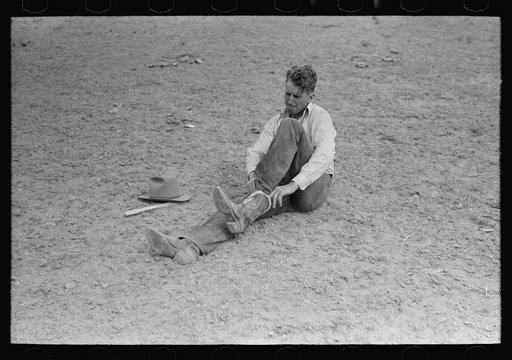 Cowboy pulling on boots, rodeo, Quemado, New Mexico