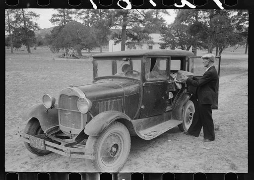 Mr. Bill Stagg putting container of food which was left from dinner at the community sing back into the car. Pie Town, New Mexico