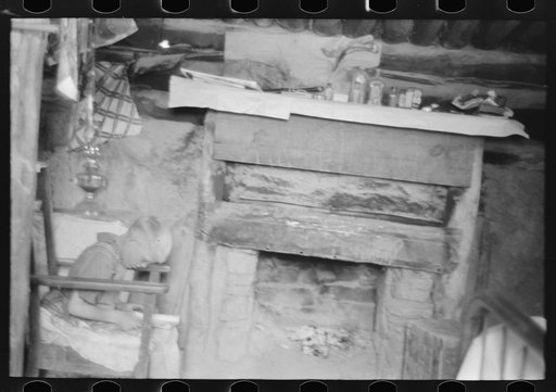 Untitled photo, possibly related to: Mr. Leatherman's son reading in front of fireplace in dugout, Pie Town, New Mexico