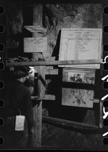 Untitled photo, possibly related to: Miner using telephone at 500-foot level at gold mine. Mogollon, New Mexico