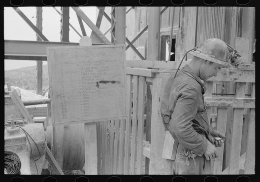 Gold miner looking at his watch before going down in the mine for work, Mogollon, New Mexico
