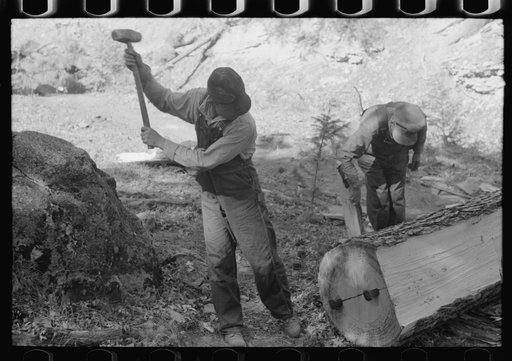 Untitled photo, possibly related to: Tie workers driving steel wedges into a pine log to split it, Pie Town, New Mexico