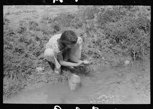 Spanish-American washing in irrigation ditch, Chamisal, New Mexico