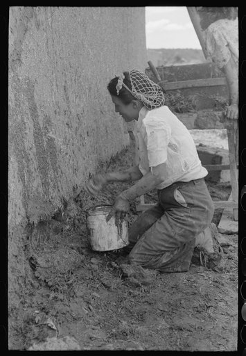 Spanish-American women plastering an adobe house, Chamisal, New Mexico