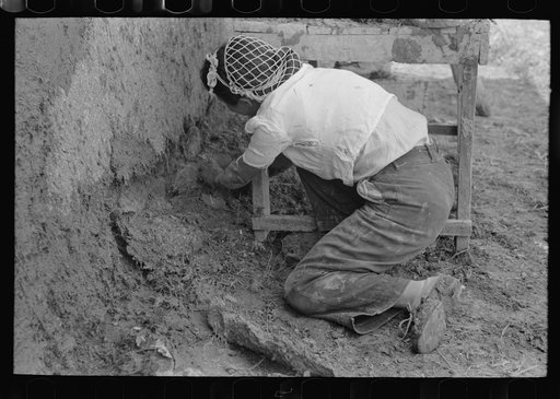 Plastering near the ground is carefully done, all old disintegrating plaster being removed. Chamisal, New Mexico