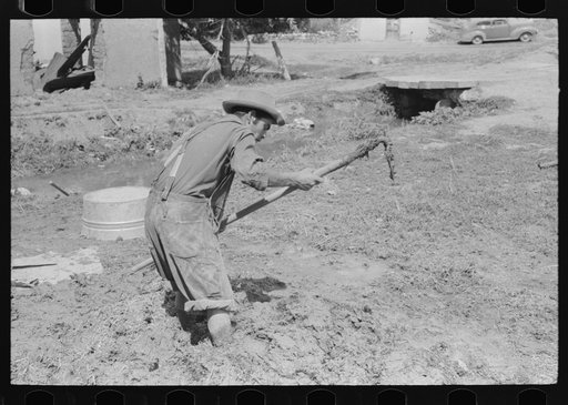 Spanish-American mixing adobe plaster, Chamisal, New Mexico