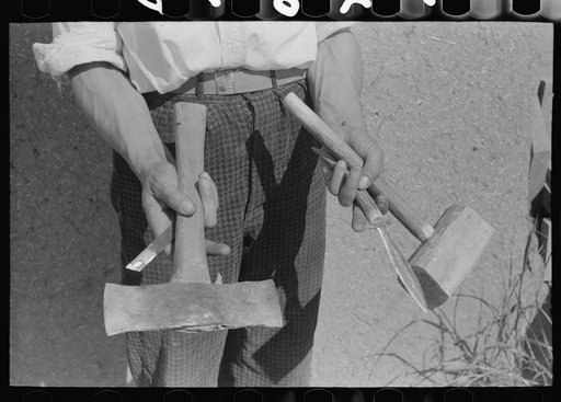 Handmade tools of Spanish-American farmer at Chamisal, New Mexico. The axe was made by welding two automobile spring leaves together and then sharpening; the dagger was filed down from a piece of automobile spring leaf and inserted in the bone handle. Chamisal, New Mexico