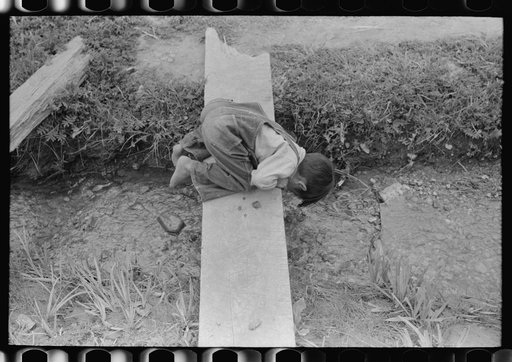 Untitled photo, possibly related to: Spanish-American boy playing in irrigation ditch, Chamisal, New Mexico