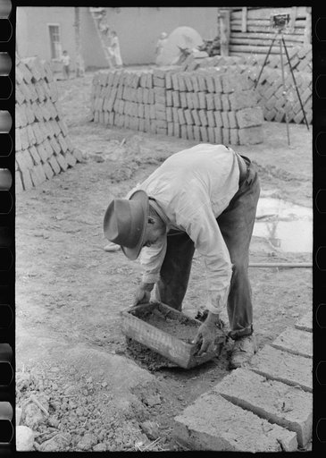 Untitled photo, possibly related to: Mixing adobe for making bricks, Chamisal, New Mexico