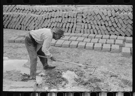 Untitled photo, possibly related to: Mixing adobe for making bricks, Chamisal, New Mexico