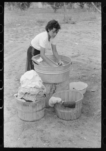 Daughter of Spanish-American farmer washing, Chamisal, New Mexico