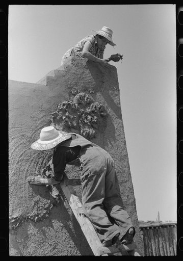Spanish-American women plastering adobe house, Chamisal, New Mexico