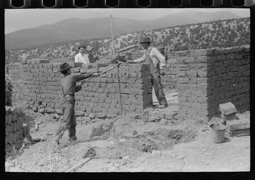 Plaster for adobe bricks to be used in building house is made from dirt dug in the front yard, Penasco, New Mexico