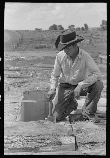 Untitled photo, possibly related to: Spanish-American boy on top of house. He is building a new roof. Amalia, New Mexico