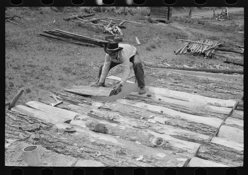 Spanish-American boy building a new roof for his home. Slabs of wood are used as a support for the mud that is later spread on. Amalia, New Mexico