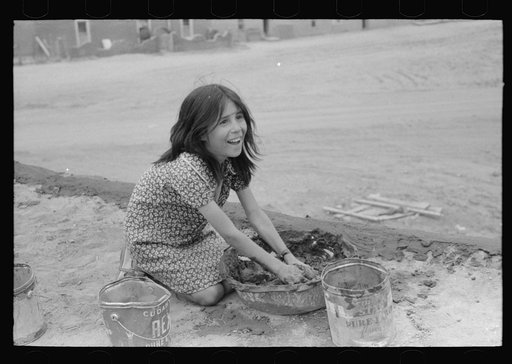 Untitled photo, possibly related to: Spanish-American girl plastering edge of roof of adobe house. Costilla, New Mexico