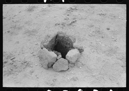 Place for stovepipe is obtained by leaving a hole in the roof of an adobe house. Costilla, New Mexico