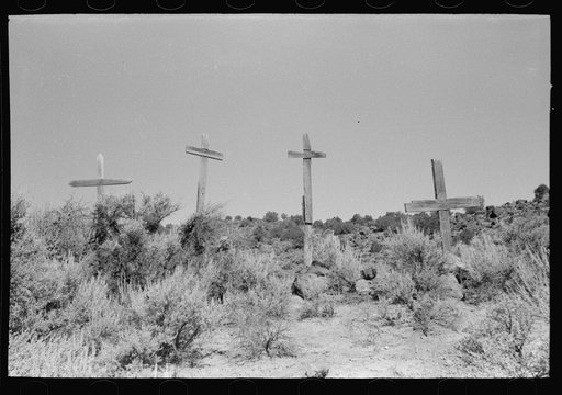 Crude wooden crosses on the hillside in the Spanish-American country. These crosses are often seen here, sometimes they mark graves and sometimes have been erected as symbols of religious feeling. Taos County, near Embudo, New Mexico