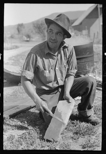 Spanish-American farmer sharpening his knife. Chamisal, New Mexico