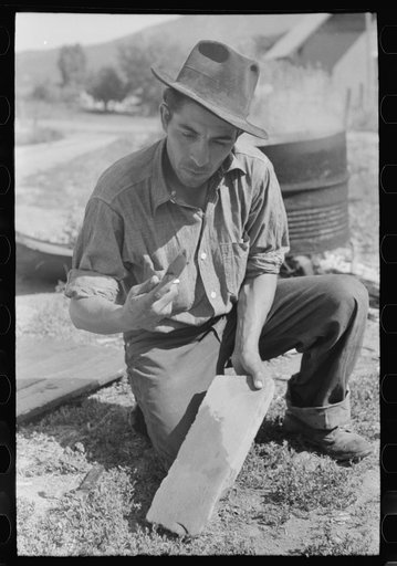 Spanish-American farmer whetting his knife. Chamisal, New Mexico