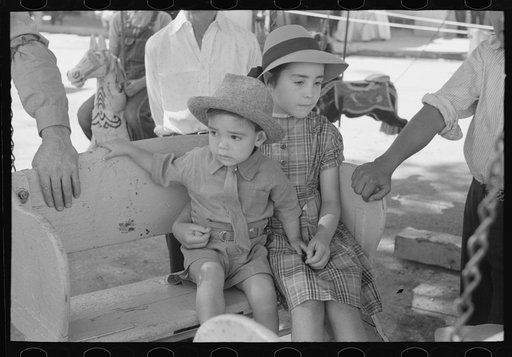 Spanish-American children waiting for a ride on the merry-go-round, Fiesta, Taos, New Mexico