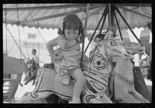 Little girl on the merry-go-round horse. Fiesta, Taos, New Mexico