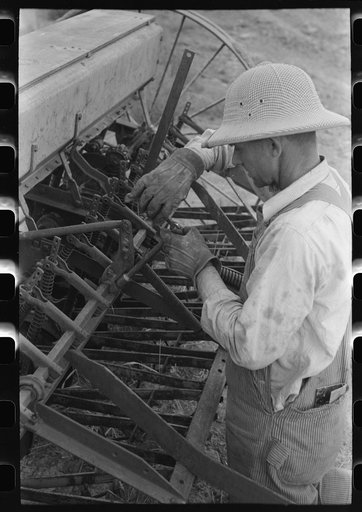 Mormon farmer working on FSA (Farm Security Administration) cooperative drill, Oneida County, Idaho. While the members of the cooperative live in Snowville, Utah, some of them farm in Oneida County, Idaho
