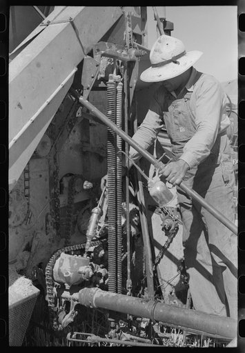 Member of FSA (Farm Security Administration) cooperative greasing the machinery, Box Elder County, Utah
