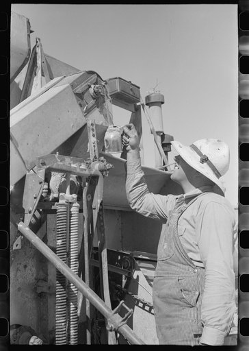 Untitled photo, possibly related to: Member of FSA (Farm Security Administration) cooperative greasing the machinery, Box Elder County, Utah