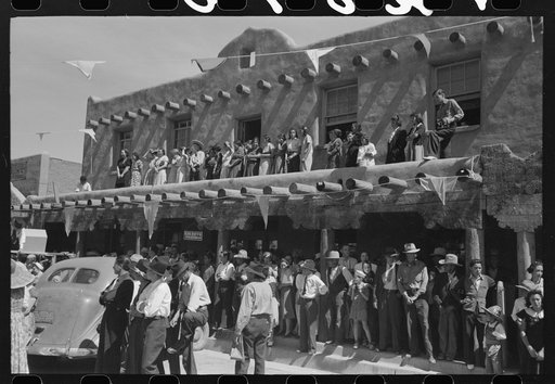 Crowds lined the streets and stood on top of covered sidewalks to see the dances at the fiesta, Taos, New Mexico