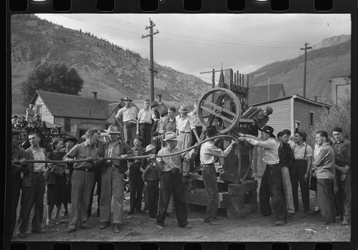 Untitled photo, possibly related to: Miner attaching airhose to power drill which he will use in drilling contest, Labor Day celebration, Silverton, Colorado