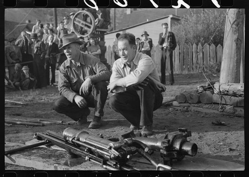 Untitled photo, possibly related to: Miner attaching airhose to power drill which he will use in drilling contest, Labor Day celebration, Silverton, Colorado