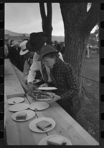 Covering a plate of barbecue sandwiches with another plate to protect the food from the rain, Labor Day at Ridgway, Colorado