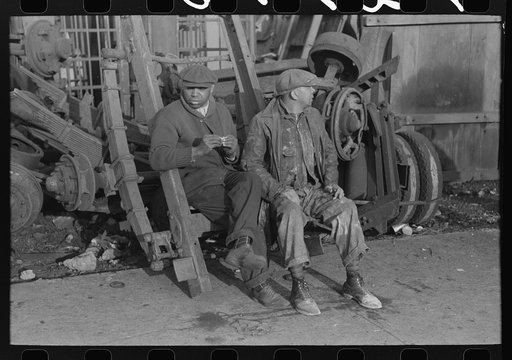 Men sitting on parts of truck in junkyard, South Side of Chicago, Illinois