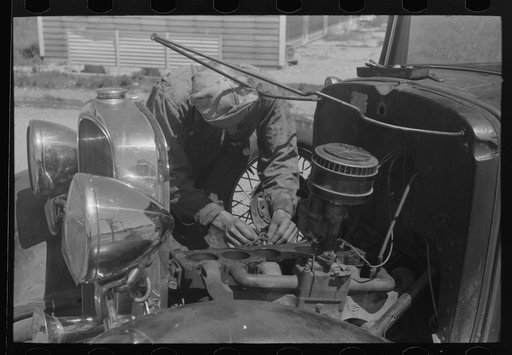 Untitled photo, possibly related to: Farm worker at work on his automobile. FSA (Farm Security Administration) labor camp. Caldwell, Idaho