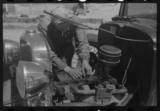 Farm worker at work on his automobile. FSA (Farm Security Administration) labor camp. Caldwell, Idaho