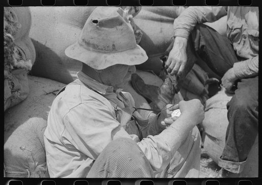 Untitled photo, possibly related to: Sheep shearers and bags of wool in the background, Malheur County, Oregon